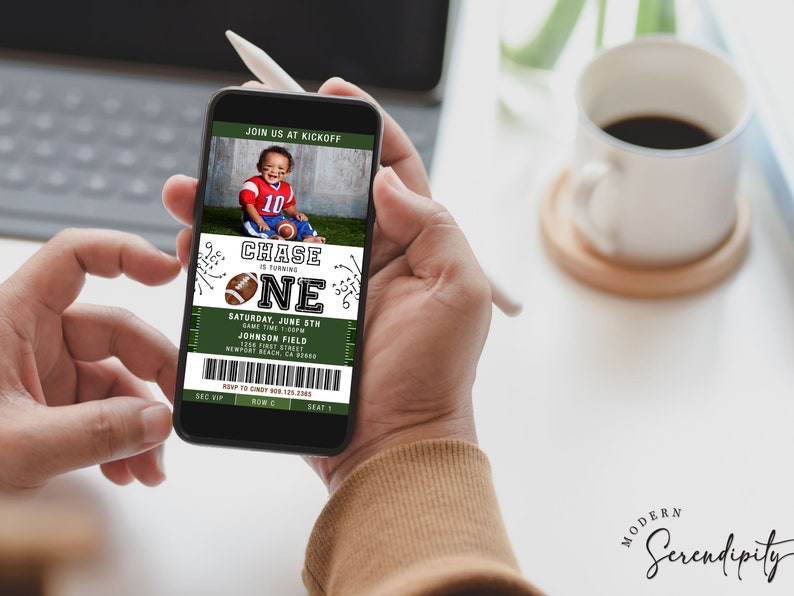 May include: A green and white football ticket invitation for a child's first birthday party. The invitation features a photo of a young boy wearing a football jersey and holding a football. The text on the invitation reads "Chase is turning one" and includes details about the party, such as the date, time, and location.