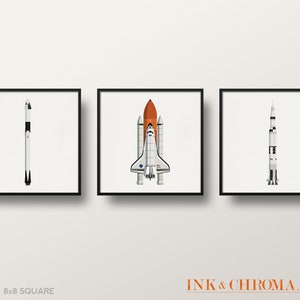 May include: Set of three 8x8 inch square prints featuring illustrations of different spacecrafts. The prints are in black frames and depict a white and black rocket, a white and orange space shuttle, and a white and black rocket.
