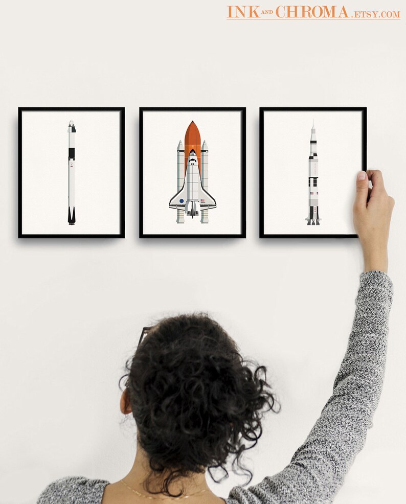 May include: Three framed illustrations of spacecrafts, including a space shuttle, a rocket, and a satellite. The illustrations are in a minimalist style with white backgrounds and black outlines.