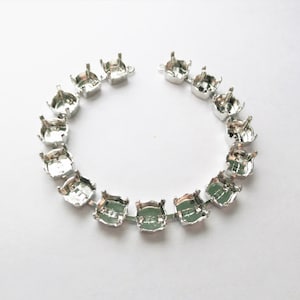 May include: A silver chain of round, open-backed settings for rhinestones or other embellishments.