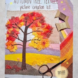 Op de afbeelding: Een Autumn Tree textielafbeelding knutselpakket met een stoffencollage van een boom met gerafelde rode, oranje en gele stoffen bladeren, een bruine stam en een landschapsachtergrond. Inclusief twee garenklosjes, een schaar en stofresten.
