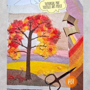 May include: A textile art piece featuring a tree with red, orange, and yellow frayed fabric leaves, a brown trunk, and a landscape of yellow, purple, and brown fabric strips. Includes two cardboard thread spools, scissors, and text reading TUTORIAL PDF.