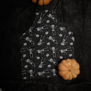 Skeleton Dance Halloween Apron – Spooky Kitchen Apron with Pumpkin Heads and Skeletons – Halloween Party Cooking and Baking Apron