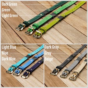 May include: A collection of nine adjustable straps in various colors, including dark green, green, light green, light blue, blue, dark blue, dark gray, gray, and beige. Each strap features a metallic buckle and a sliding metal connector.