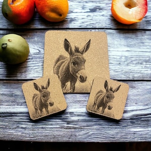 May include: Three cork coasters with a black and white illustration of a donkey on each. The coasters are on a wooden surface.