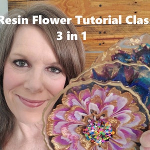 Può includere: Una donna tiene in mano tre sottobicchieri in resina. Un sottobicchiere presenta un fiore rosa e bianco con dettagli dorati e glitter colorati. Gli altri due sottobicchieri hanno un design a spirale blu e viola con dettagli dorati. Il testo "Resin Flower Tutorial Class 3 in 1" è visualizzato sopra la donna.