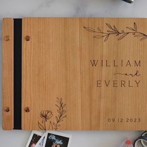 Minimalist bamboo wedding guest book in an cherry wood finish with engraved, customized couples names and a boho leaf design on the cover.