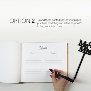May include: A white guest book with the word "Guests" written in black cursive. The book is open to a page with lines for names and thoughts. A black marker is being used to write in the book. A black "Mr & Mrs" sign is in the top right corner of the image.