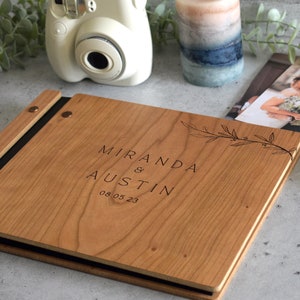 Engraved wooden wedding guest book in an amber finish with customized couples names and boho leaf design engraving.