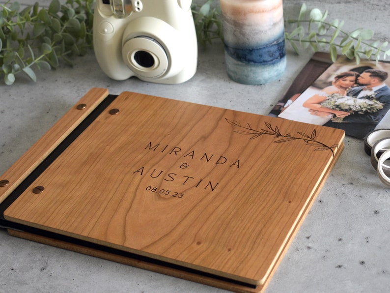 Engraved wooden wedding guest book in an amber finish with customized couples names and boho leaf design engraving.