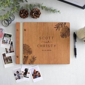 Custom wedding guest book engraved tropical leaf design. Fully customizable, it’s perfect for capturing special memories at weddings and significant events. for Polaroid photos, this guest book offers a unique and personalized keepsake.