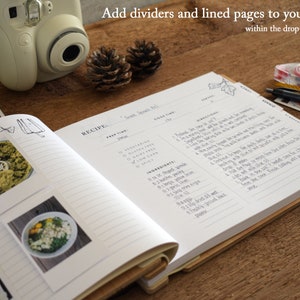 May include: Open recipe book with lined pages and dividers. The book has a recipe for "Sweet Potato Roll" with a list of ingredients and directions. The book has a wooden cover and is open to a page with a photo of a green dip.