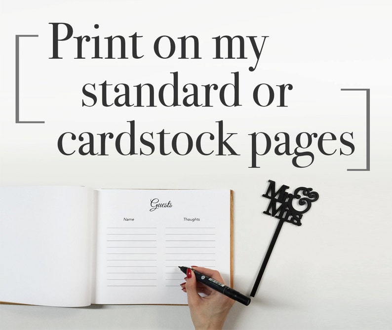 May include: A white guest book with the word "Guests" written in cursive on the cover. The book is open to a page with lines for names and thoughts. A black marker is being used to write in the book. A black "Mr. & Mrs." sign is in the background.