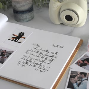 a photo book with photos and a camera on a table