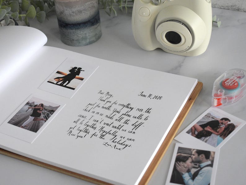 a photo book with photos and a camera on a table