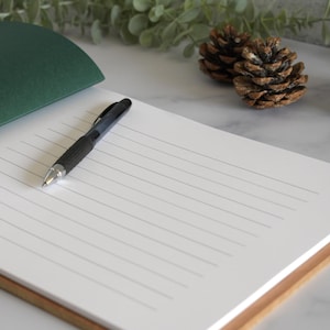 a notepad with a pen sitting on top of it