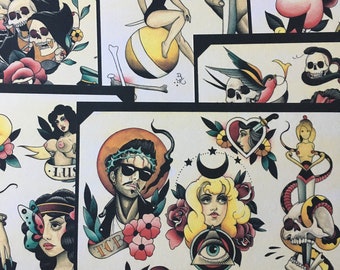 May include: A collection of colorful tattoo flash designs featuring a variety of subjects, including a woman on a ball, a skull with a snake, a man with a crown of thorns, and a woman with an eye in a triangle. The designs are drawn in a traditional style with bold lines and bright colors.