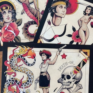 May include: A set of four vintage-style tattoo flash designs. The designs include a woman with a crown and a rose, a seahorse, a man's head with a bandana, and a woman with wings and a skull. The designs are all in black and white and have a traditional tattoo style.