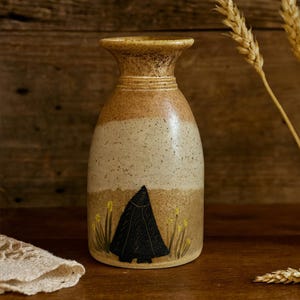 May include: A set of three ceramic mugs with a speckled, matte finish in cream, light brown, and dark brown. Each mug has a simple, minimalist design, ideal for tea or coffee.