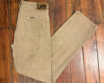 May include: A pair of beige corduroy pants with a brown leather Lee label on the back waistband.