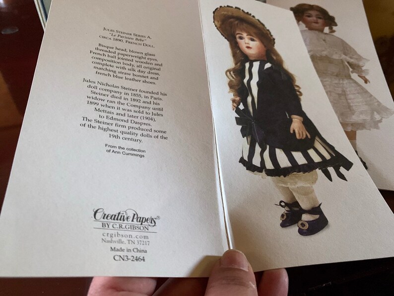 Puede incluir: Una mu&ntilde;eca francesa vintage con cabeza de bisque, ojos de vidrio soplado y vestido a rayas blancas y negras. La mu&ntilde;eca lleva un sombrero de paja y zapatos negros. La tarjeta dice "Jules Nicholas Steiner A. - Le Parisien Body - Circa 1890, French Doll."