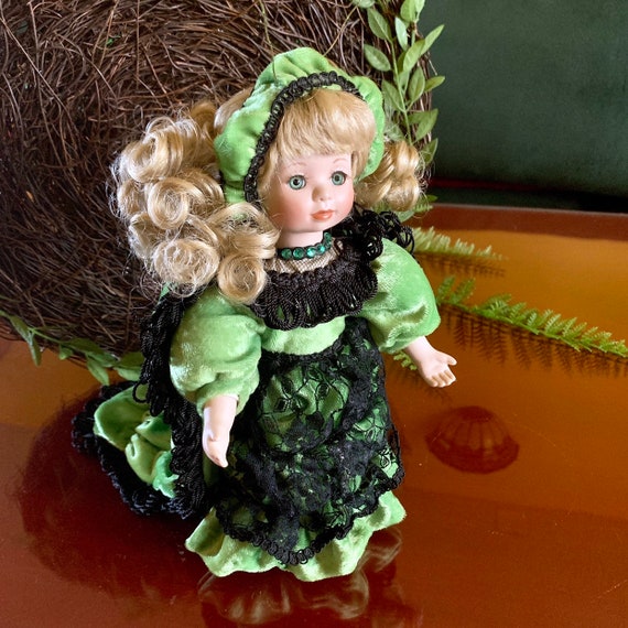 porcelain doll green dress Vintage porcelain doll with green dress and chair 29769 main image 1