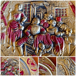 K&ouml;nnte beinhalten: Ein Vintage-Metalltablett mit einem roten und goldenen Design. Das Tablett zeigt eine Szene mit Menschen in einer l&auml;ndlichen Umgebung. Das Tablett ist mit aufwendigen Details verziert und hat einen erh&ouml;hten Rand.