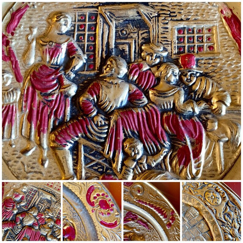K&ouml;nnte beinhalten: Ein Vintage-Metalltablett mit einem roten und goldenen Design. Das Tablett zeigt eine Szene mit Menschen in einer l&auml;ndlichen Umgebung. Das Tablett ist mit aufwendigen Details verziert und hat einen erh&ouml;hten Rand.
