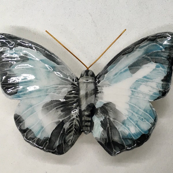 Papillon en céramique réalisé et décoré à la main. Les couleurs sont imaginaires mais la forme est celle d'un vrai papillon.