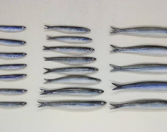 20 Sardellen aus Keramik in verschiedenen Größen, handgefertigt. Zur Befestigung an der Wand mithilfe der kleinen Löcher auf der Rückseite. Dekorativer Wandfisch.