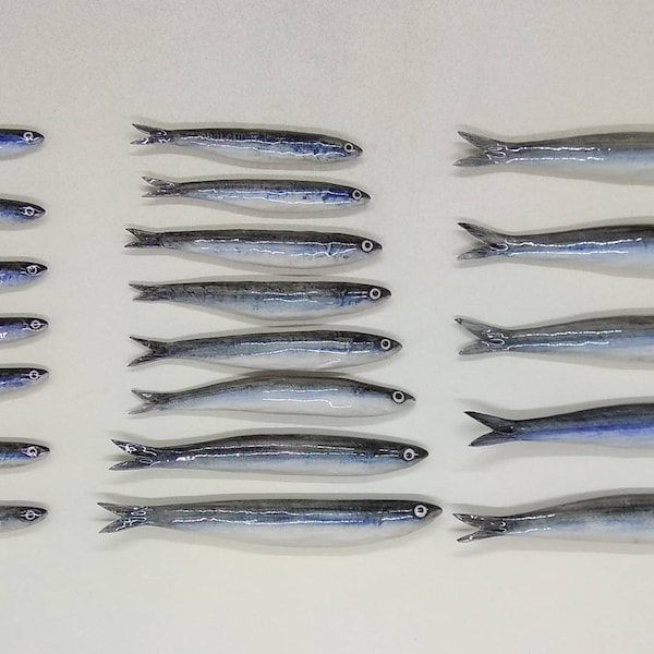 20 ceramic anchovies of various sizes, handmade. To be applied to the wall using the small holes on the back. Decorative wall fish.