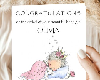 May include: A greeting card with the text "CONGRATULATIONS on the arrival of your beautiful baby girl OLIVIA". The card features an illustration of a sleeping baby girl wearing a crown and wrapped in a pink blanket.
