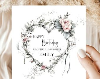 May include: A square greeting card featuring a heart-shaped wreath made of thin branches, green leaves, and soft pink roses. The text in the center reads HAPPY Birthday BEAUTIFUL DAUGHTER EMILY in black lettering against a plain white background.