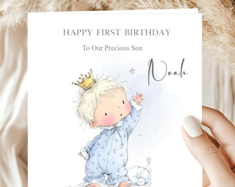 May include: A greeting card with the text "HAPPY FIRST BIRTHDAY To Our Precious Son Noah". The card features an illustration of a baby wearing a crown and pajamas, reaching for a star.