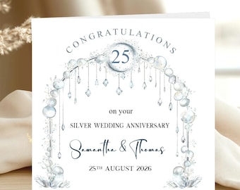 May include: A white greeting card with the text "Congratulations" and "25" in a silver design. The card is for a silver wedding anniversary, with the names "Samantha & Thomas" and the date "25th August 2026".