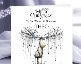 May include: A square white greeting card featuring a whimsical illustration of a reindeer with large antlers decorated with hanging ornaments and stars. The text reads Merry Christmas To Our Wonderful Grandson THEO in black lettering.