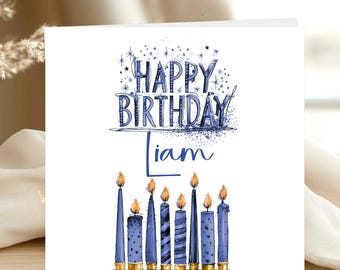 May include: A square greeting card with a white background featuring the blue text HAPPY BIRTHDAY LIAM. Below the text are eight blue candles of varying heights and patterns with orange flames. The design includes small blue star accents.