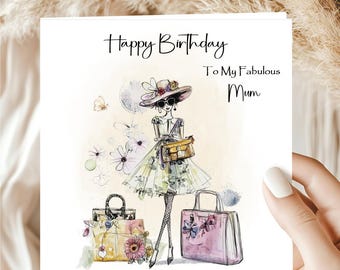 May include: A birthday card with the text "Happy Birthday To My Fabulous Mum." The card features a fashion illustration of a woman in a hat and sunglasses, holding a purse, with two handbags at her feet. The illustration is in soft watercolor tones.
