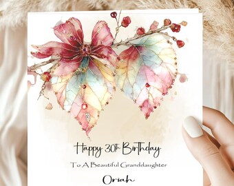 May include: A birthday card with a watercolor design. The card features a floral arrangement with pink, red, and pastel-colored leaves. The text reads "Happy 30th Birthday To A Beautiful Granddaughter Oriah."