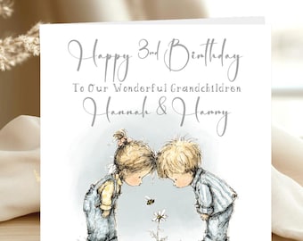 May include: A birthday card with the text "Happy 3rd Birthday To Our Wonderful Grandchildren Hannah & Harry." The card features an illustration of two children looking at a bee and a flower. The card has a white background.