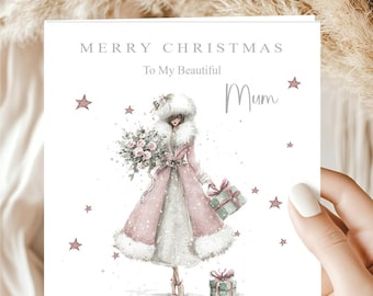 May include: A square Christmas greeting card featuring a watercolor illustration of a person in a pink coat with white fur trim, holding a bouquet of pink roses and a gift. The text reads MERRY CHRISTMAS To My Beautiful Mum with pink stars.
