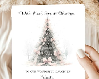 May include: A square greeting card featuring a watercolor illustration of a dark green Christmas tree decorated with soft pink ribbons. The text reads With Much Love at Christmas at the top and TO OUR WONDERFUL DAUGHTER Felicity at the bottom.