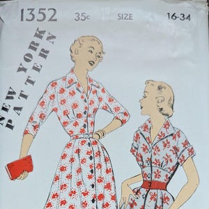 May include: Vintage New York Pattern sewing pattern. The cover features illustrations of two women wearing floral print dresses. The dresses have button-up fronts and are cinched at the waist with belts. The pattern size is 16-34.