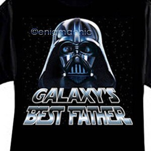 Puede incluir: Camiseta negra con un gráfico de Darth Vader y el texto "Galaxy's Best Father".