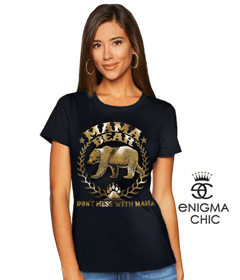 Puede incluir: Camiseta negra con un gr&aacute;fico dorado de un oso y el texto "Mama Bear" y "Don't Mess With Mama".