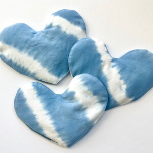 Pode incluir: Tr&ecirc;s almofadas em forma de cora&ccedil;&atilde;o azul e branco com estampa tie-dye. As almofadas s&atilde;o feitas de tecido macio e t&ecirc;m um sutil padr&atilde;o tie-dye.