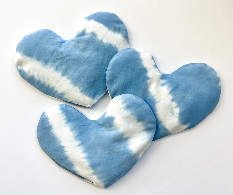 Pode incluir: Tr&ecirc;s almofadas em forma de cora&ccedil;&atilde;o azul e branco com estampa tie-dye. As almofadas s&atilde;o feitas de tecido macio e t&ecirc;m um sutil padr&atilde;o tie-dye.