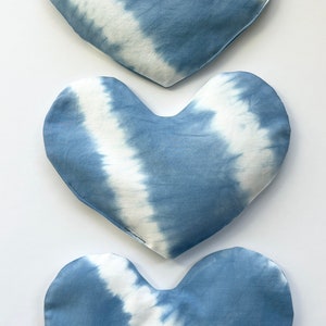 Pode incluir: Tr&ecirc;s almofadas em forma de cora&ccedil;&atilde;o azul e branco com tie-dye. As almofadas s&atilde;o feitas de um tecido de algod&atilde;o macio e t&ecirc;m um visual sutil e desbotado.