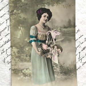 Antike französische Postkarte, schöne Frau im blauen Kleid mit rosa Blumen, handkolorierte echte Fotografie, Jugendstil, St Marthe