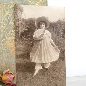 Antike Postkarte, hübsches Mädchen im Rüschenkleid mit Mütze und Fächer, echte Fotografie